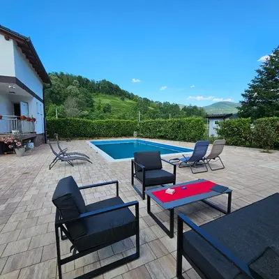 a patio with chairs and a table and a pool at Vikendica na Sani Datea in Sanski most