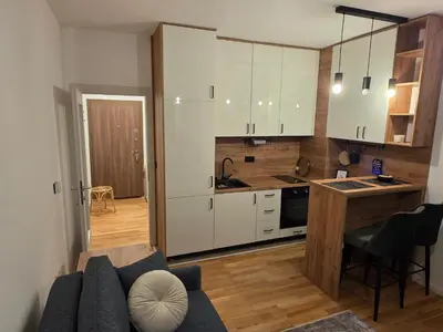 a kitchen with white cabinets and a couch in a room at Terra Lux in Travnik