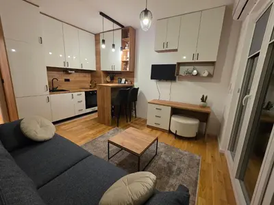 a living room with a couch and a kitchen at Terra Lux in Travnik