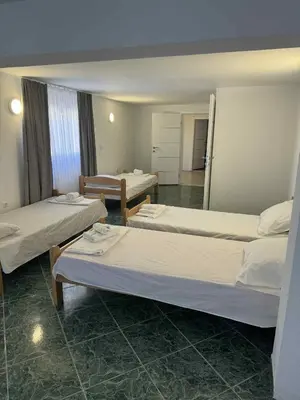 a room with three beds and a mirror at Dvorac Kastel in Ljubače