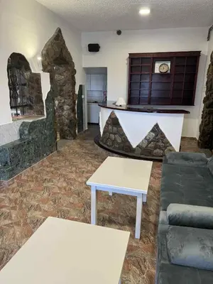 a living room with a couch and a stone fireplace at Dvorac Kastel in Ljubače