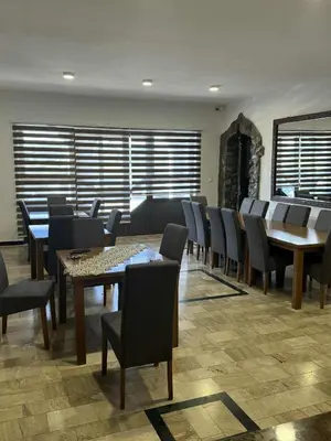 a dining room with tables and chairs and a fireplace at Dvorac Kastel in Ljubače