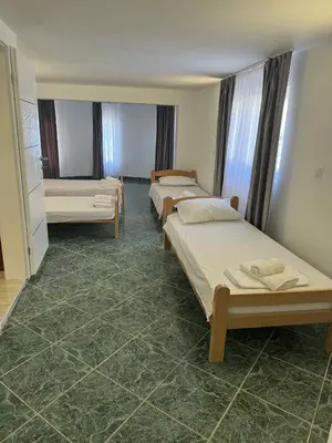 three beds in a room with green tile floors at Dvorac Kastel in Ljubače