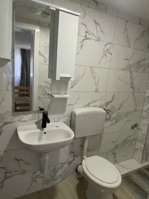 a white bathroom with a toilet and a sink at Dvorac Kastel in Ljubače