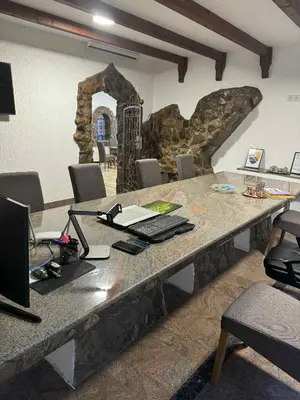an office with a large table with chairs and a stone wall at Dvorac Kastel in Ljubače