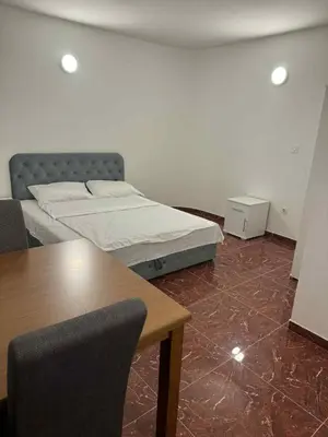 a bedroom with a bed and a table with chairs at Dvorac Kastel in Ljubače