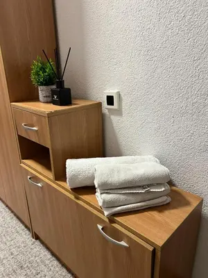 a wooden shelf with towels on it in a room at Apartman Rejjan in Zenica