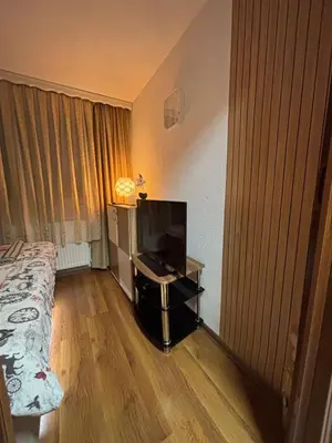 a room with a bed and a television on a table at Apartman Rejjan in Zenica