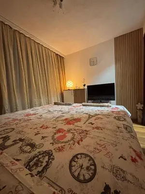 a bedroom with a bed with a clock on it at Apartman Rejjan in Zenica