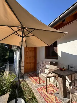 a patio with an umbrella and a table and chairs at Oaza Vrbas - Riverside Bungalow near Jajce in Vinac