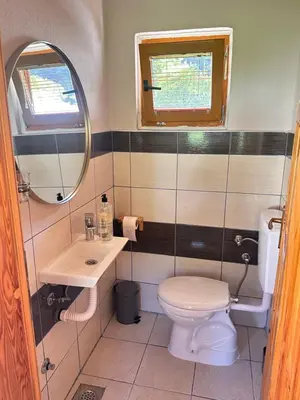 a bathroom with a toilet and a sink and a mirror at Oaza Vrbas - Riverside Bungalow near Jajce in Vinac