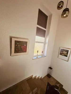 a living room with a staircase and a window at SWISS Apartment in Pokoj