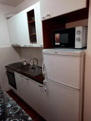 a kitchen with a microwave on top of a refrigerator at AnyBL02 in Hiseti