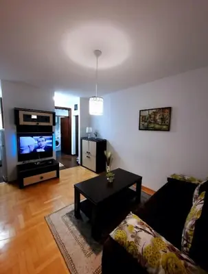 a living room with a couch and a flat screen tv at AnyBL02 in Hiseti