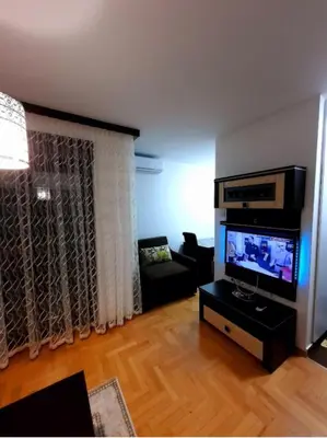 a living room with a flat screen tv and a couch at AnyBL02 in Hiseti
