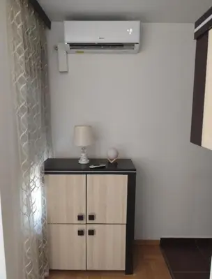 a room with a dresser with a lamp on it at AnyBL02 in Hiseti