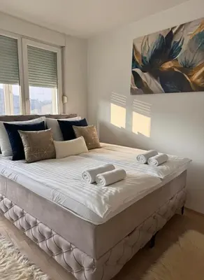 a bedroom with a large bed with towels on it at Apartment Meskovic in Tuzla