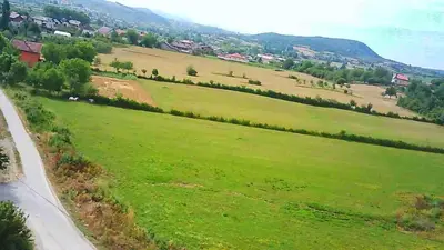 a green field with houses and a road at Apartman Ventus in Bihać