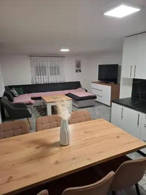 a room with a table and a living room at Apartman Ventus in Bihać