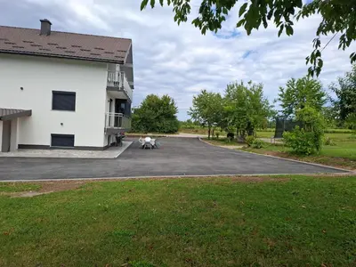 a dog sitting in a parking lot next to a building at Apartman Ventus in Bihać