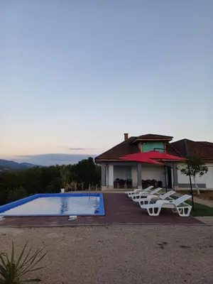 a swimming pool with lounge chairs and a house at Vikendica Hangover in Gradačac
