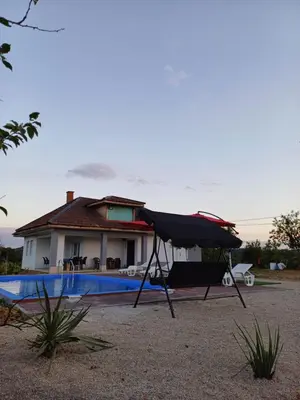 a house with a swimming pool and a black umbrella at Vikendica Hangover in Gradačac