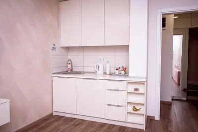 a kitchen with white cabinets and a sink at Royal Imperial in Doboj