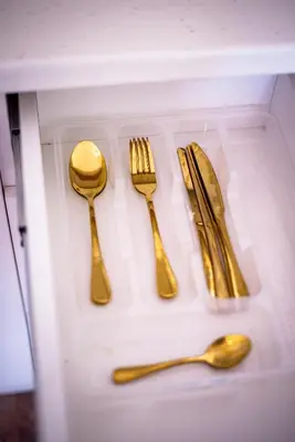 a group of gold utensils in a drawer at Royal Imperial in Doboj
