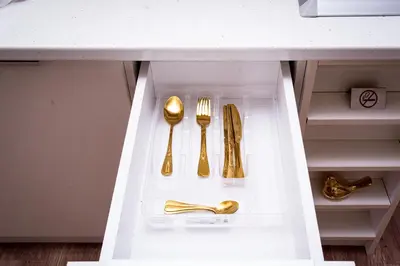 a white drawer with gold utensils in a kitchen at Royal Imperial in Doboj