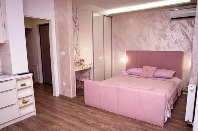 a pink bedroom with a bed and a dresser at Royal Imperial in Doboj