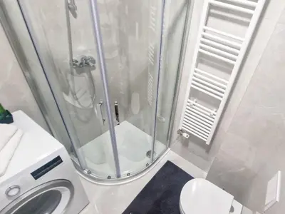 a bathroom with a shower with a toilet and a sink at Cozy Home II in Banja Luka
