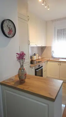 a kitchen with a vase on a counter with a clock at Cozy Home II in Banja Luka