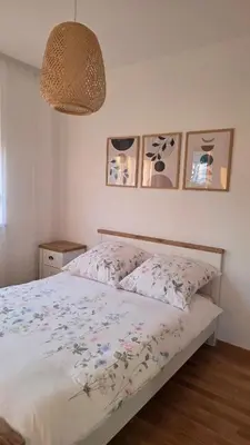 a bedroom with a bed with a floral bedspread at Cozy Home II in Banja Luka