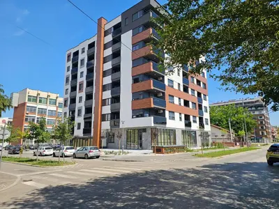an apartment building on a street with parked cars at Cozy Home II in Banja Luka