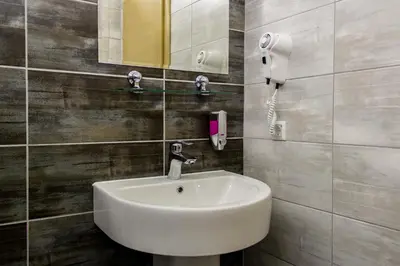 a bathroom with a sink and a mirror and a phone at Motel Calypso Travnik in Travnik