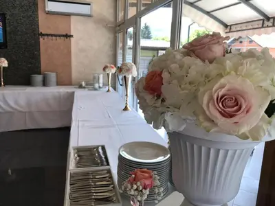 a white vase filled with flowers on a table at Motel Calypso Travnik in Travnik