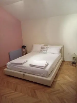 a large white bed in a room with a wooden floor at Villa S&M in Ivišovo Greblje