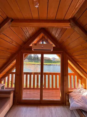 a bedroom with a large window in a wooden house at Sofkin salas in Prijedor