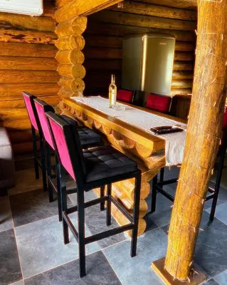 a wooden table with chairs and a bottle of wine at Sofkin salas in Prijedor