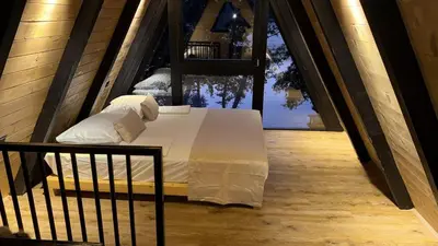 a bedroom with a bed on a balcony with a window at Wooden Houses D&D in Jajce