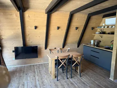 a kitchen and dining room with a table and chairs at Wooden Houses D&D in Jajce
