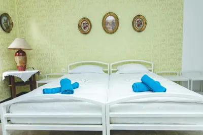 a white bed with blue pillows on top of it at APP&ROOMS MG Jablanica in Jablanica