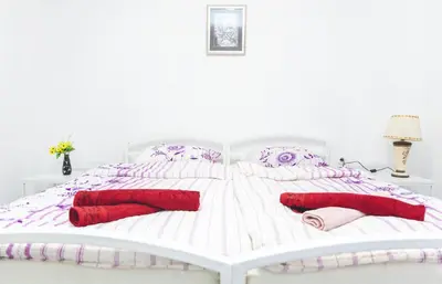a white and purple bed with red pillows on it at APP&ROOMS MG Jablanica in Jablanica