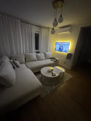 a living room with a white couch and a tv at Apartman I&I in Kiseljak