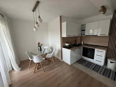 a kitchen with a table and chairs in a room at Apartman I&I in Kiseljak