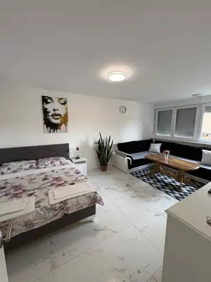 a bedroom with a bed and a living room at Stan na dan - zvijezda Danica Kozarska Dubica in Bosanska Dubica