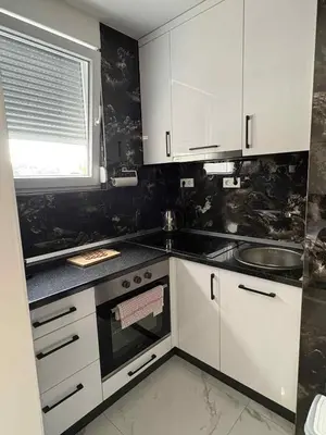 a kitchen with white cabinets and a window at Stan na dan - zvijezda Danica Kozarska Dubica in Bosanska Dubica