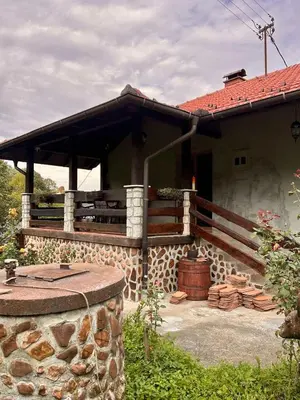 a house with a porch and a fire pit at Vikendica Dion in Srebrenik