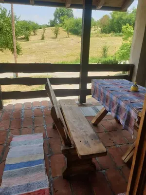 a wooden bench sitting on a patio with a table at Vikendica Dion in Srebrenik