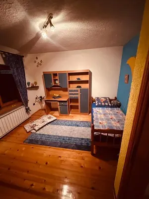 a bedroom with two beds and a desk in it at Vikendica Dion in Srebrenik